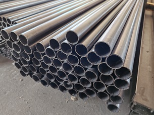 Egy bontott köteg D42,4x2 mm-es hegesztett acélcső, háttérben egyéb vasanyagok - kismetalvasker.hu